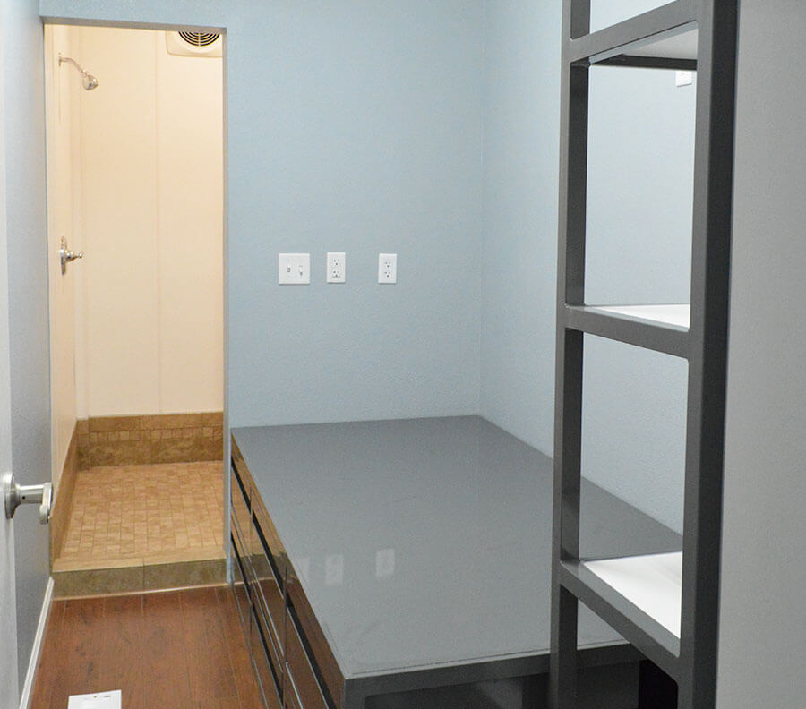 En-suite bedrooms equipped with a bed and shelving.