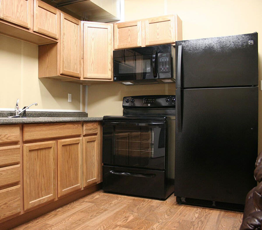 Kitchens include fitted cupboards and appliances.