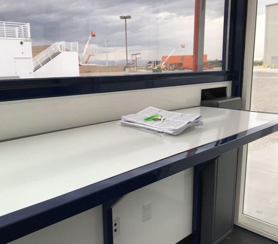 Integrated shelving and desks provide spacious work areas for security paperwork and log books.